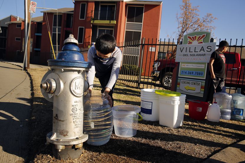 Ivan Garcia, a young resident of the Villas Del Solamar Apartments, fills his water bucket...
