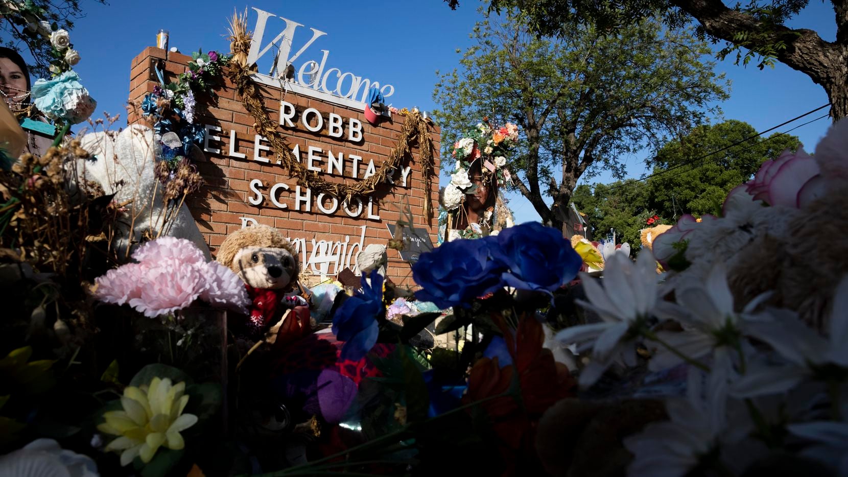 A memorial honoring the nineteen students and two teachers who were killed stands outside of...
