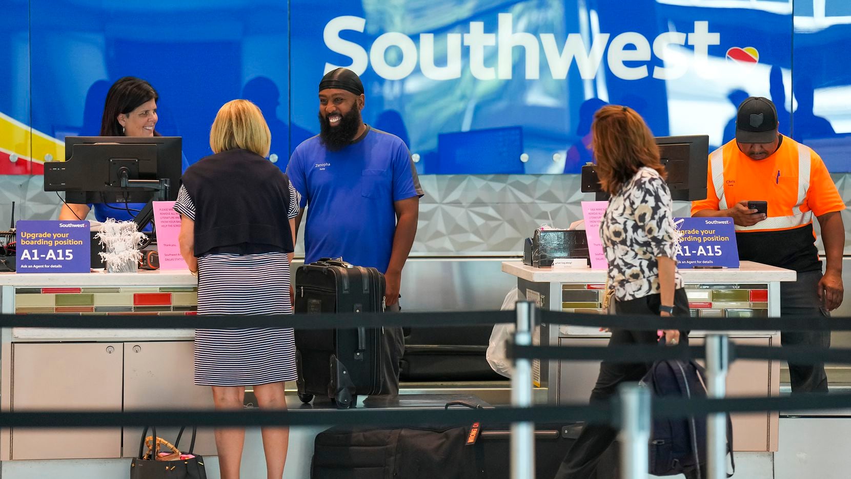 Southwest Airlines ticketing and ramp agents work at a check-in desk at Dallas Love Field in...