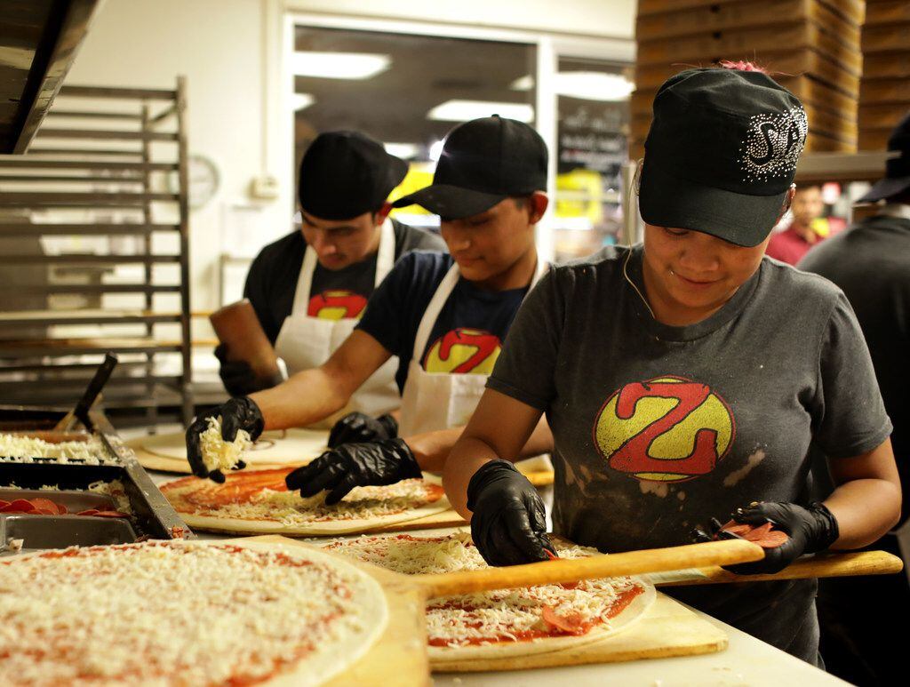 Employees prepare a steady flow of pizzas during a 2 a.m. rush at Zalat Pizza on Fitzhugh...