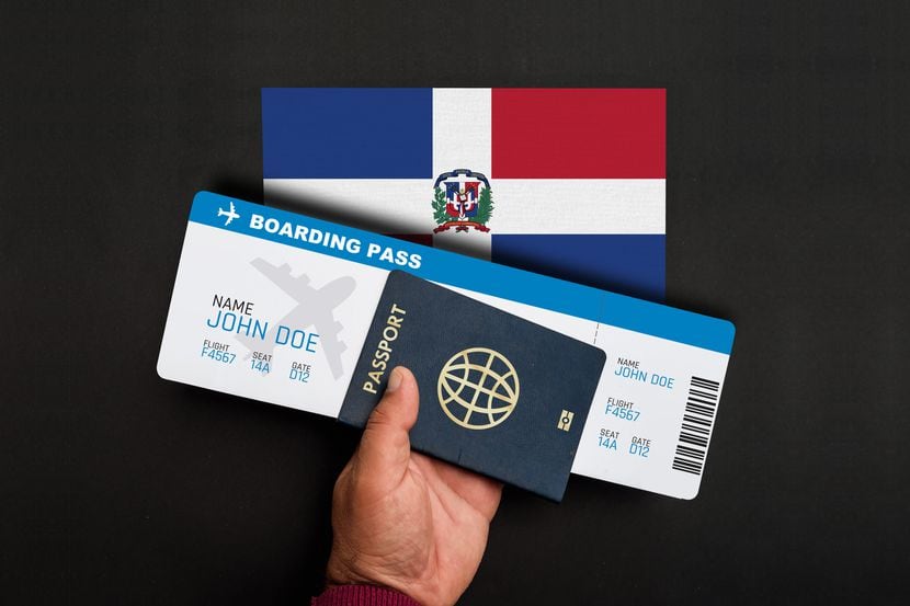 Una persona porta un pasaporte y un boleto de avión.