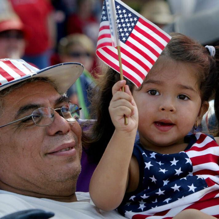 Decked in patriotic colors, Jose Flores and his granddaughter watch the 2016 Arlington...