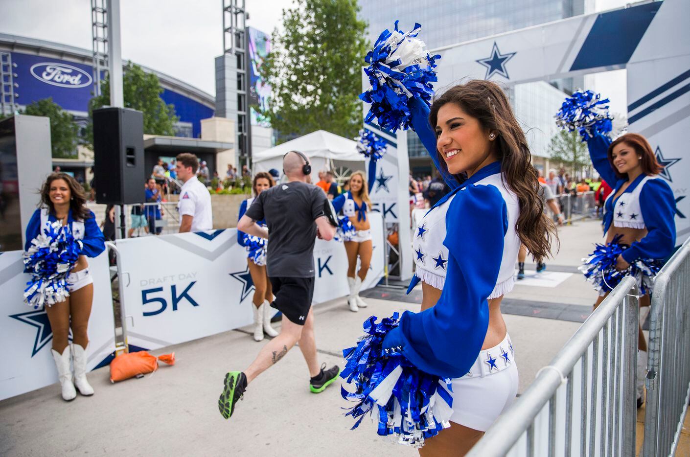 Dallas Cowboys cheerleader Selina Flores (center) and other cheerleaders encourage runners as they reach the finish line of the Dallas Cowboys Draft Day 5K during day three of the Dallas Cowboys' 2017 NFL Draft Party on Saturday, April 29, 2017, at The Star in Frisco.