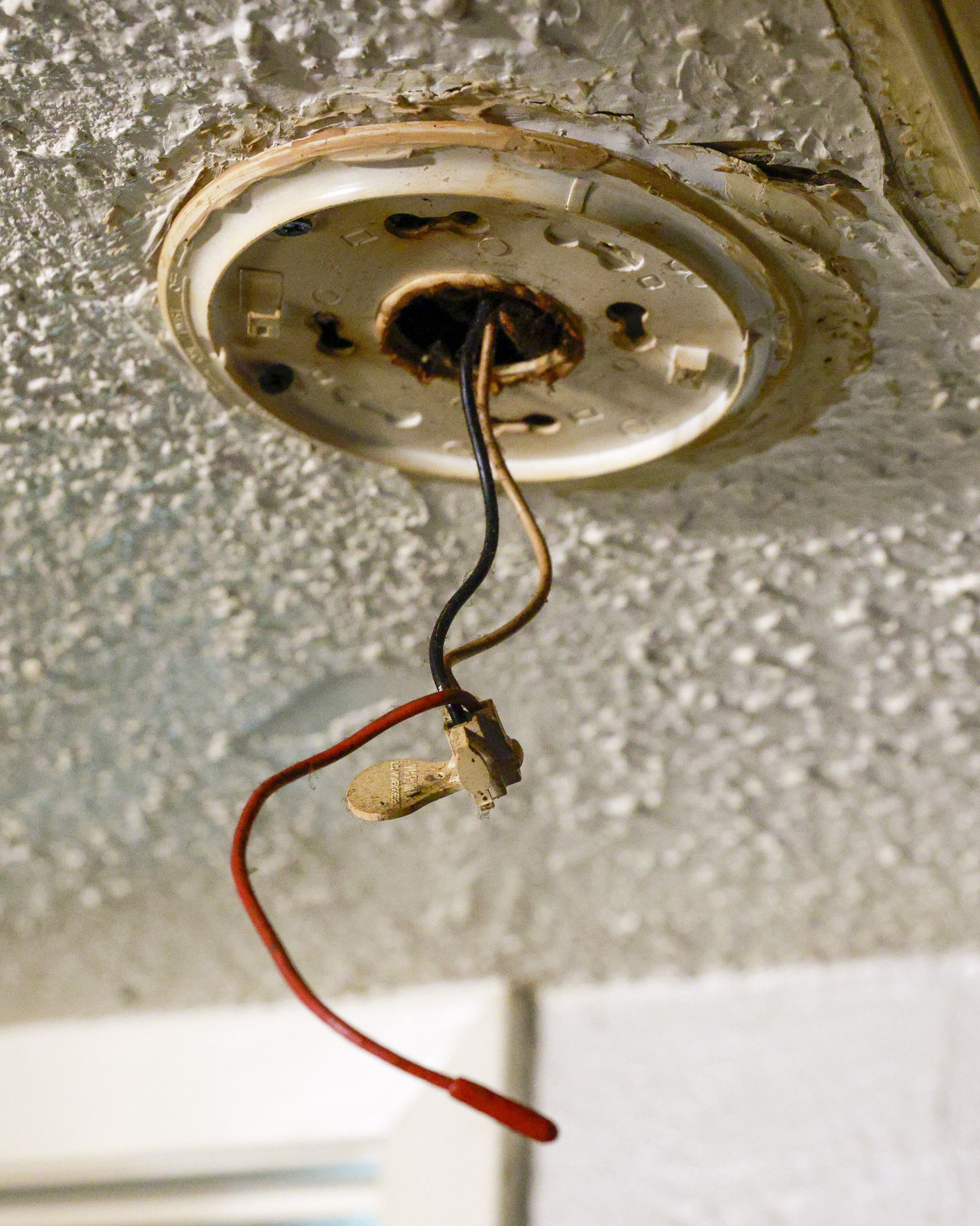Wiring sits exposed where a smoke alarm should sit in the ceiling of Destiny Morris’...