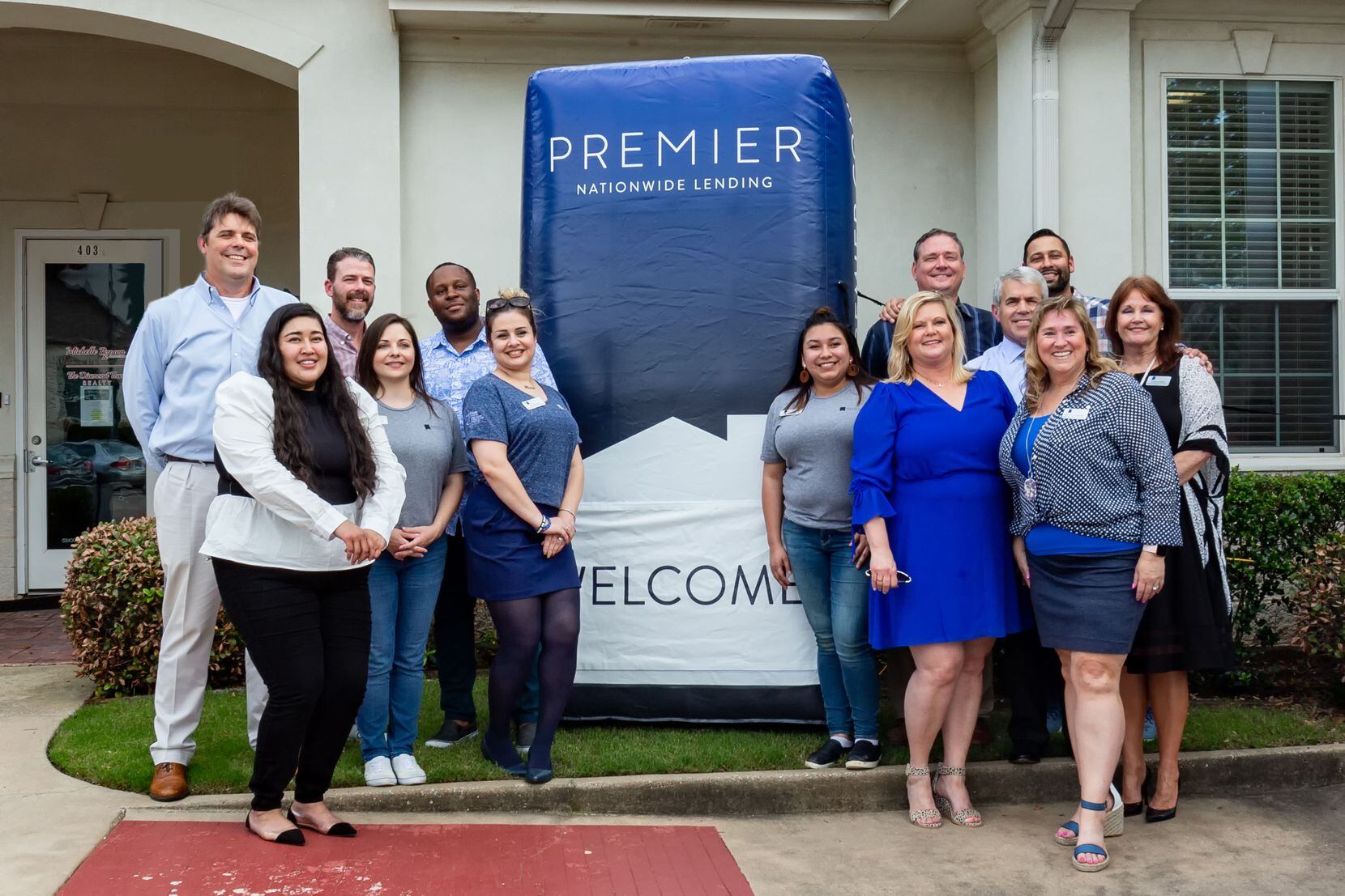Premier Nationwide Lending employees are shown at a ribbon cutting for its branch in Flower...