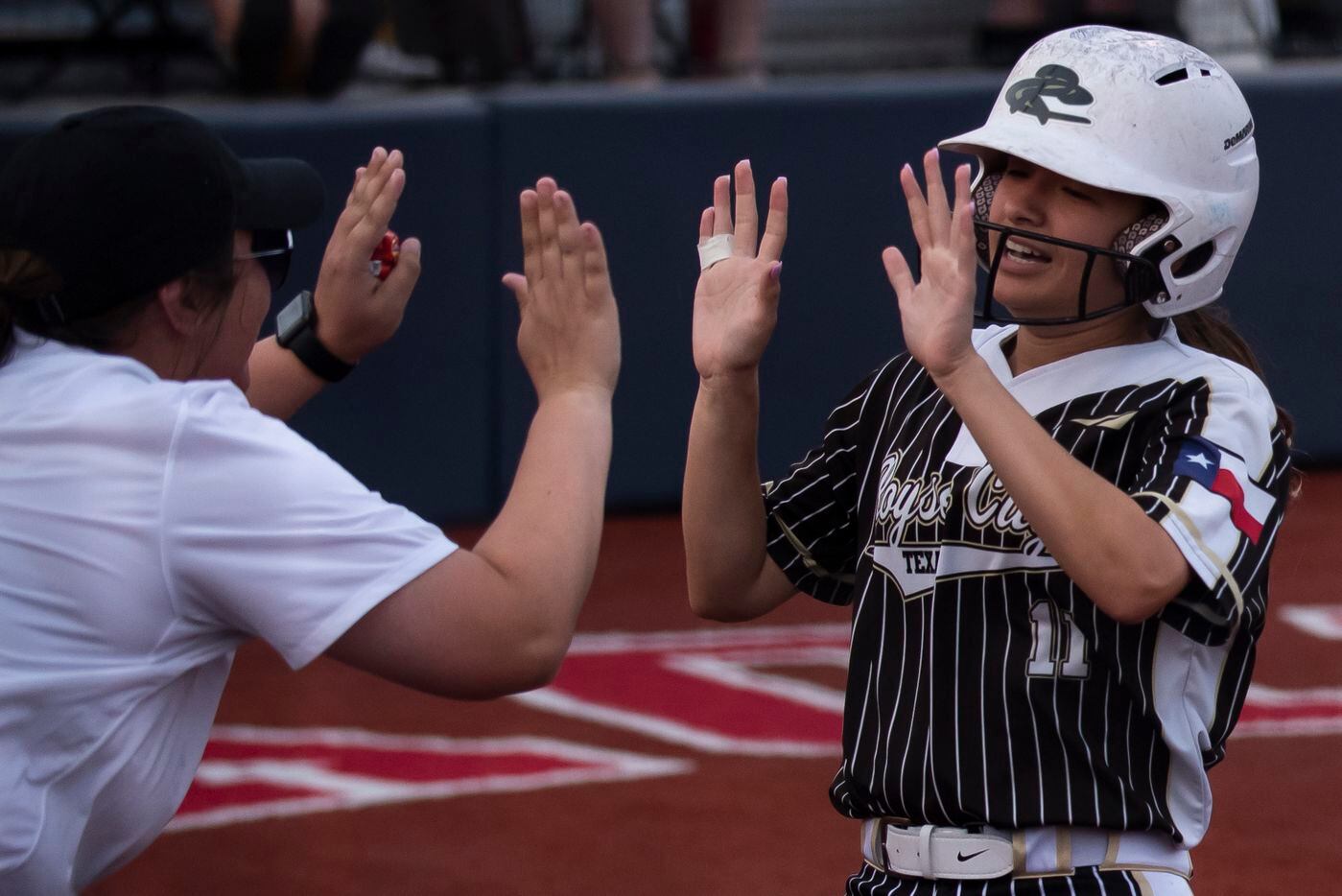 Royse City’s Haley Alaniz (11) high fives a coach after scoring a run during game two of the...