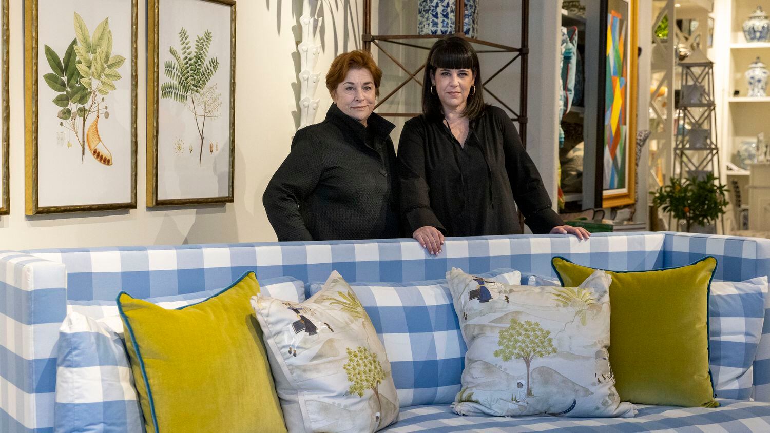 Owners Teddie Garrigan (left) and Courtney Garrigan stand with their blue-and-white checked sofa that is the subject of a trademark case at Coco & Dash in Dallas.