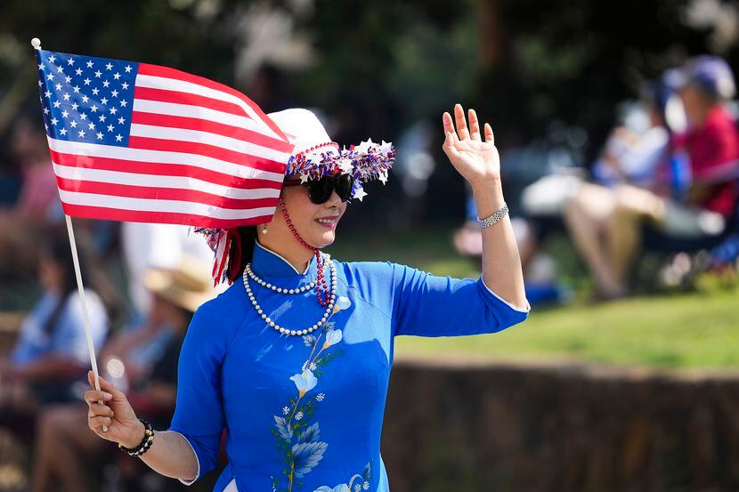 Hien Nguyen waves to spectators while marching with members of the Vietnamese American...