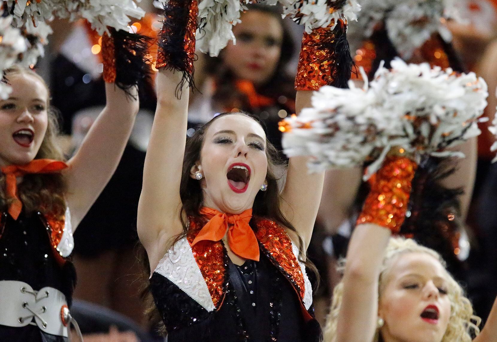 A member of the Rockwall High School drill team cheers during the first half as Rockwall...