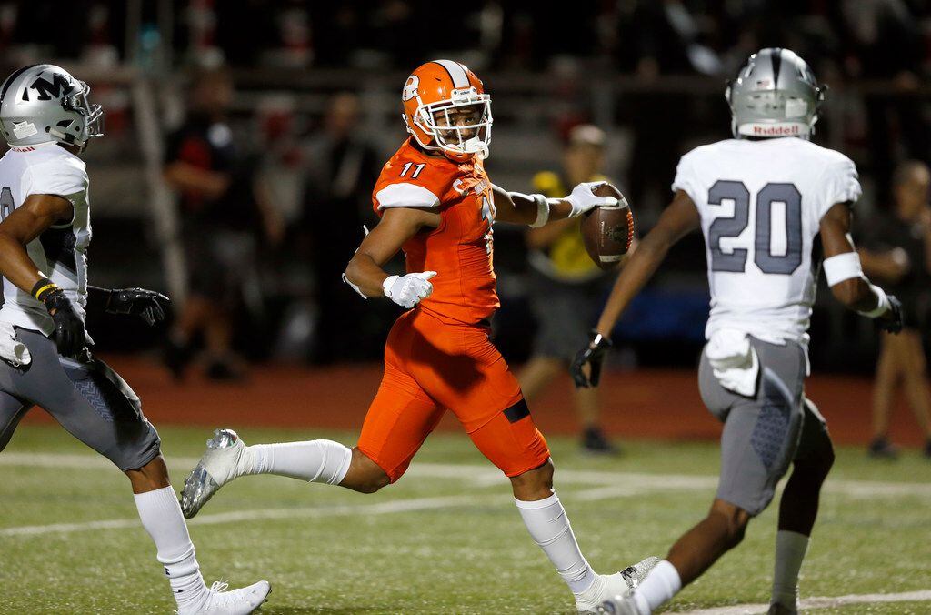 Rockwall's Jaxon Smith-Njigba (11) runs in for a touchdown in front of Arlington Martin's...