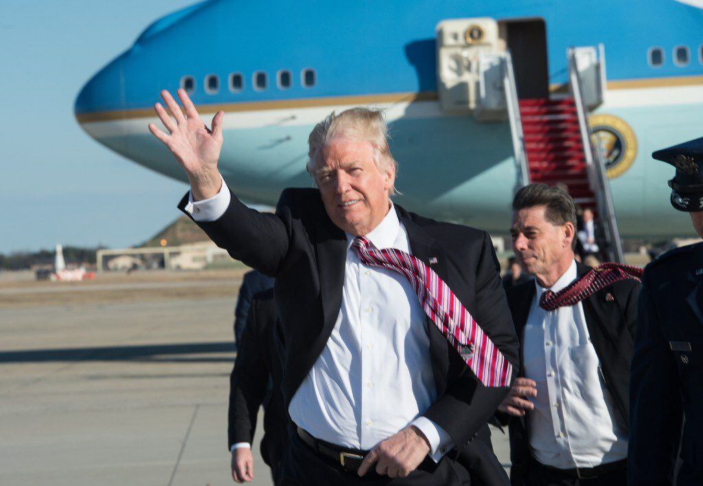 President Donald Trump waves after stepping off Air Force One at Joint Base Andrews on...