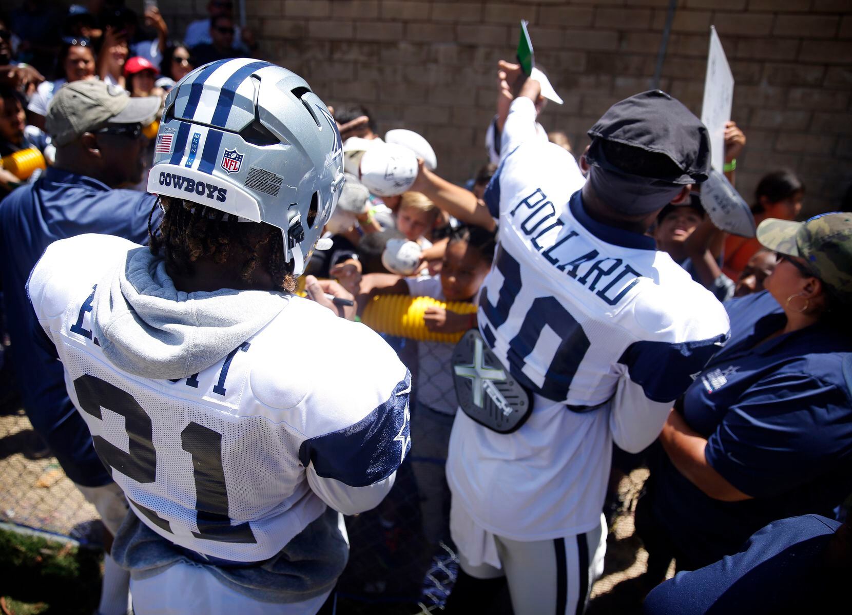 Dallas Cowboys running backs Ezekiel Elliott (21) and Tony Pollard (20) sign autographs for...