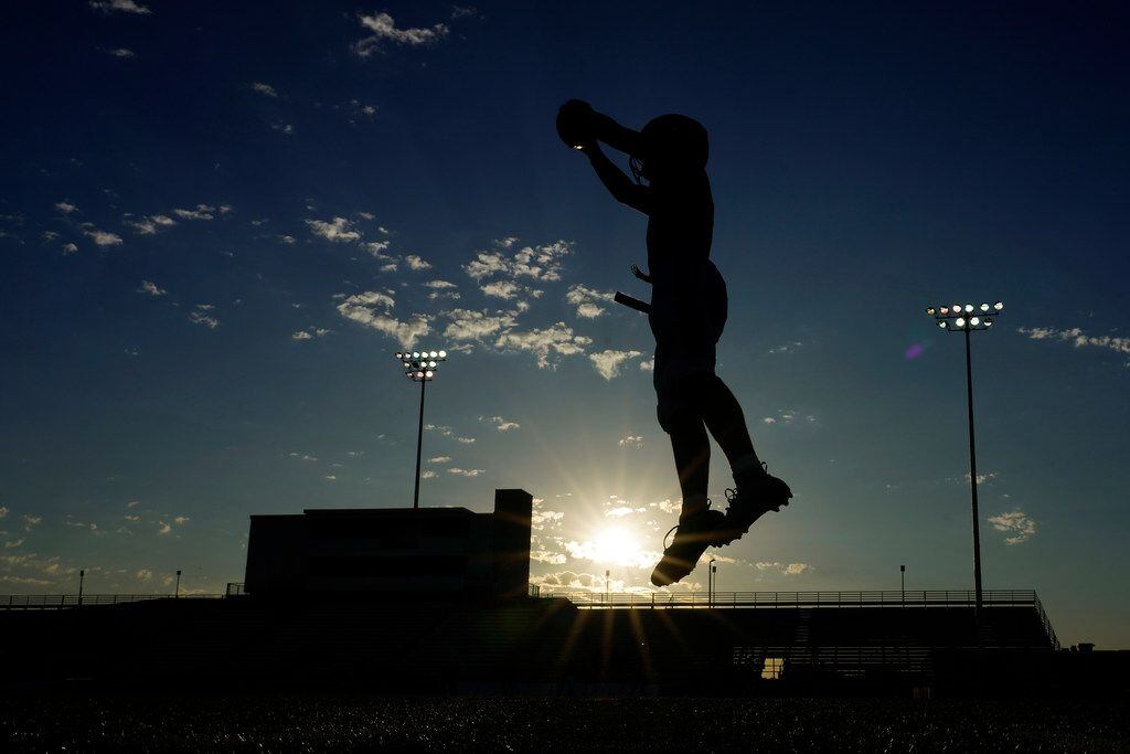 Arlington players warm up before a high school football game against the Arlington Bowie at...