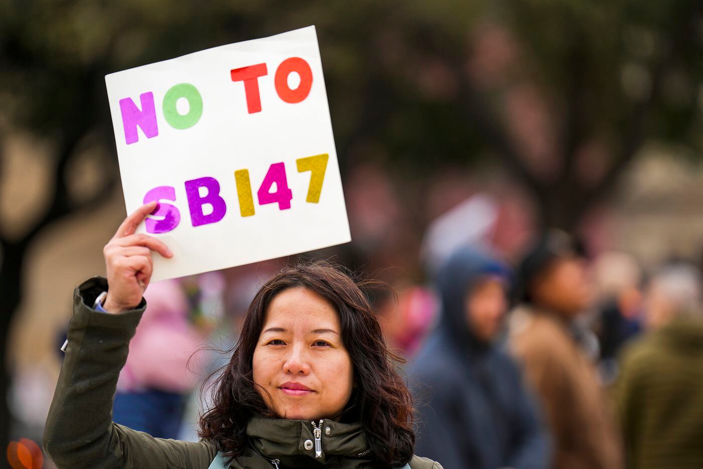 Liu Yang holds a sign in opposition to Texas Senate Bill 147 during a rally on Sunday, Jan....
