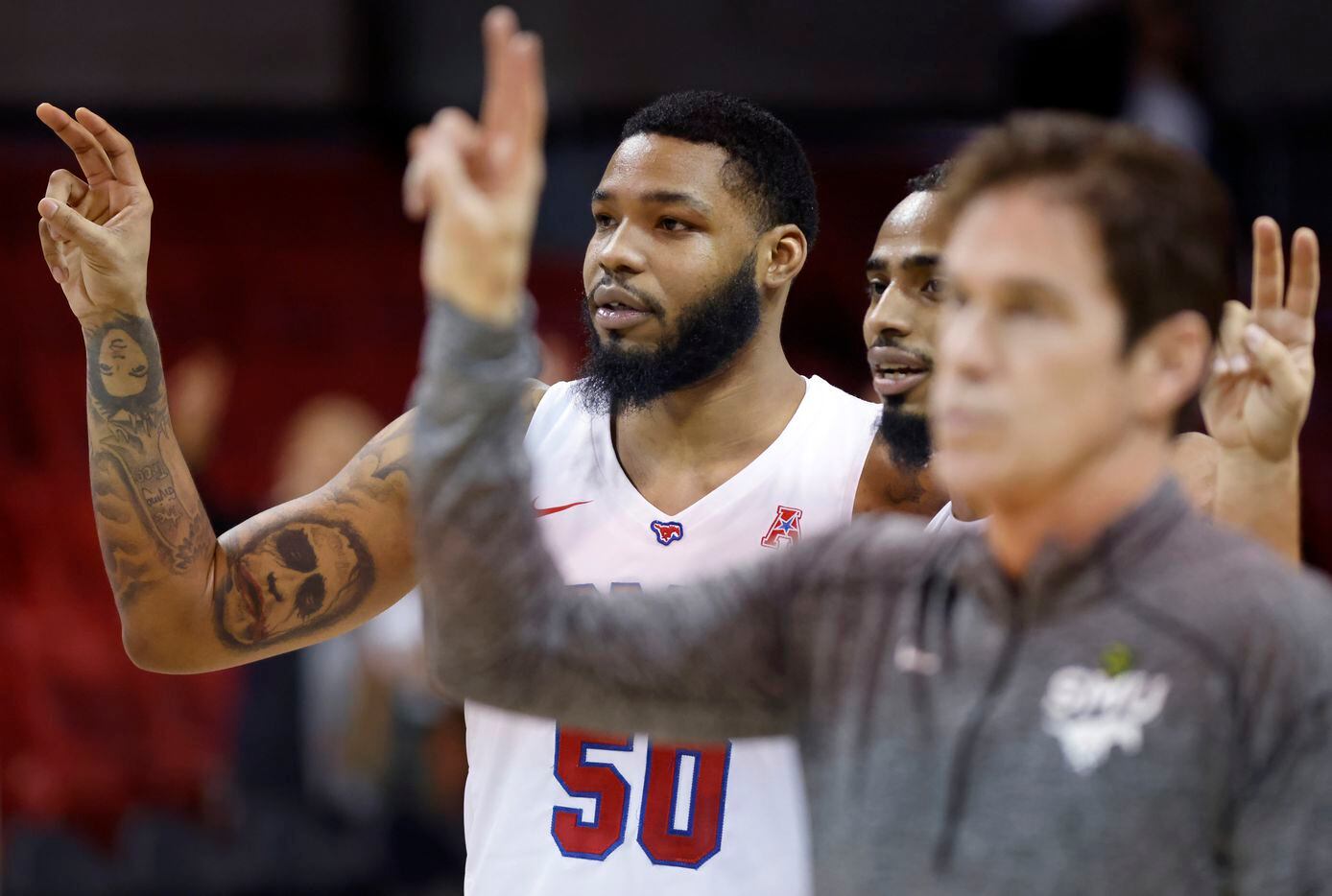 Southern Methodist Mustangs forward Marcus Weathers (50) and head coach Tim Jankovich listen...