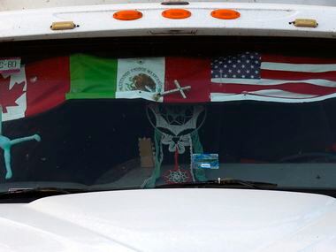 A semi-truck with a Canada, Mexico and US flag sits at a rest stop near the Pharr–Reynosa...