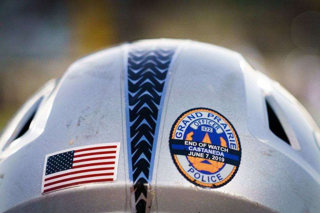 Stickers on the helmets of Arlington Martin players honor Grand Prairie police officer A.J....