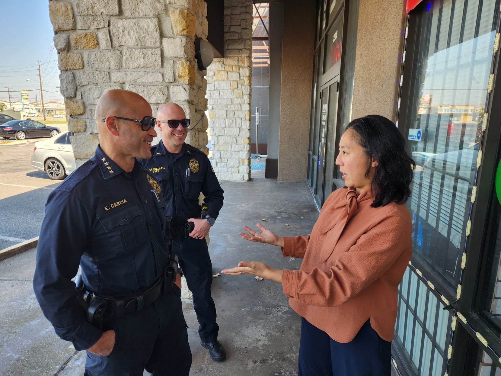 Dallas Police Chief Eddie Garcia walks through the city's Koreatown alongside Caroline Kim,...