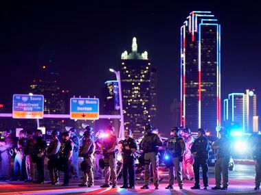 Law enforcement officers block the western side of the Margaret Hunt Hill Bridge while...