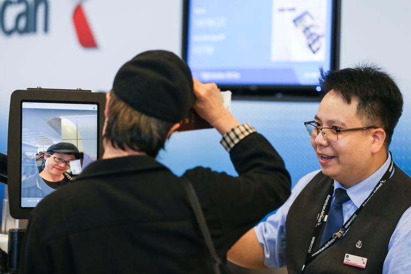 El agente Steven Phu ayuda a un pasajero abordar un vuelo de American Airlines del...