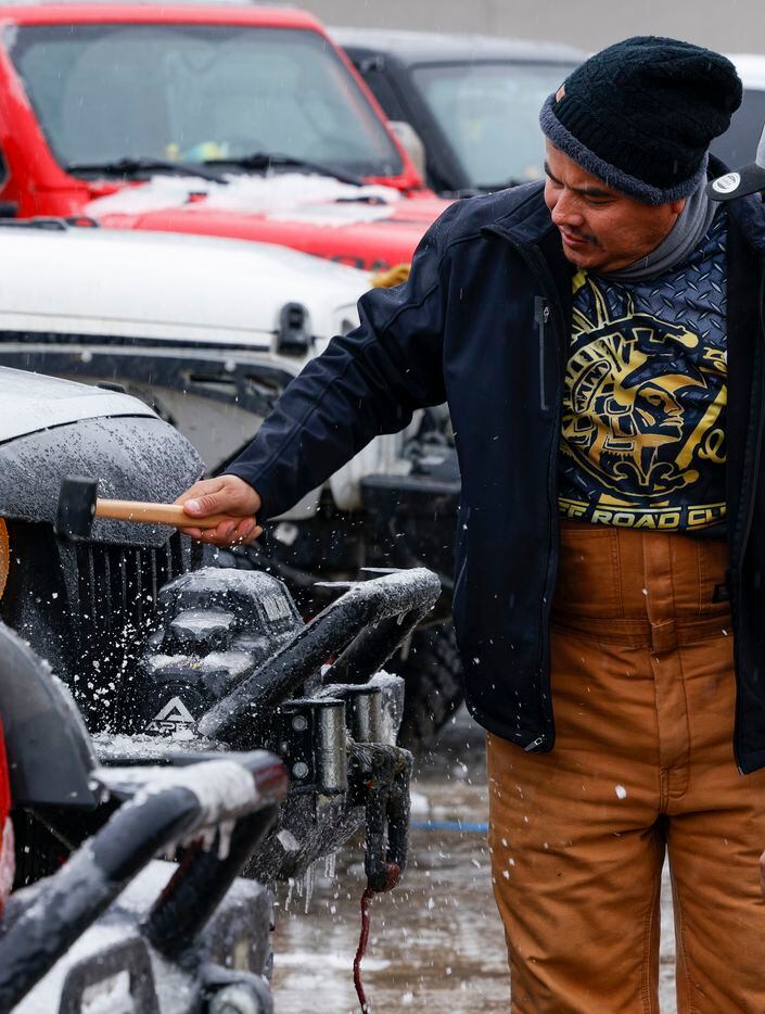David Torres, Carnales Off Road member, knocks ice off a Jeep in West Dallas, Wednesday,...