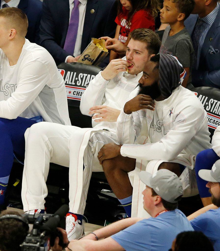 Team LeBron's Luka Doncic (2) eats a handful of Garrett's popcorn on the bench during the...