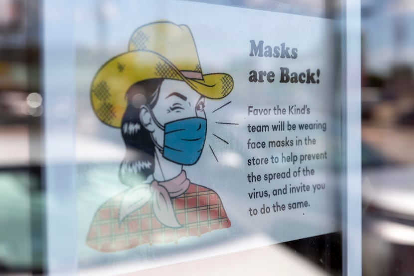 A sign at Favor the Kind on North Henderson in Dallas encourages customers to wear face...