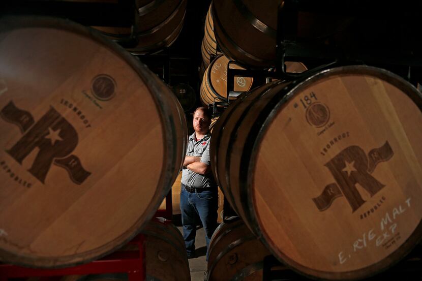Co-owner Robert Likarish poses for a photograph with barrels of whiskey in the distillery at...