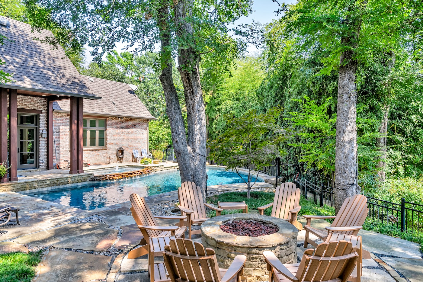 Not only does the backyard boast a pool, covered patio, outdoor kitchen and green space, but...