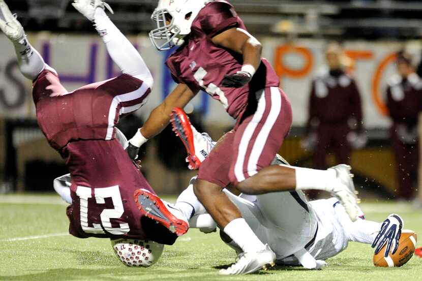 Allen linebacker Tay Evans and Plano quarterback Brooks Panhans (27) scramble to recover a...