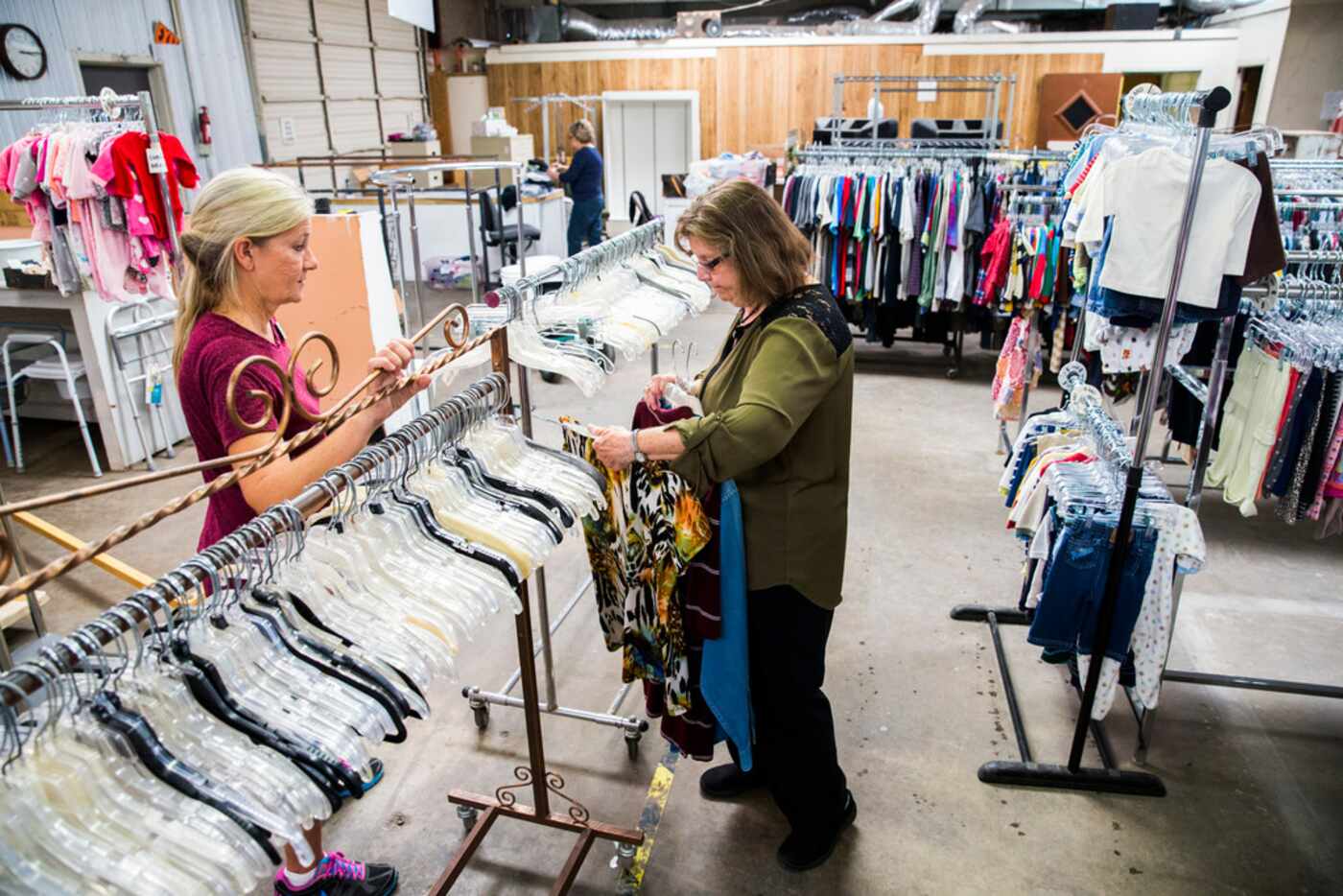 Director Gayle Schielack (left) talks to volunteer Maxine Ballard while sorting clothing at...