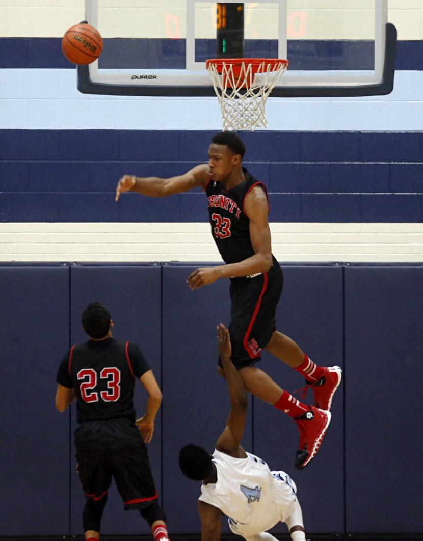 Euless Trinity Basketball player Myles Turner (33) rejects a shot from L.D. Bell's Malik...