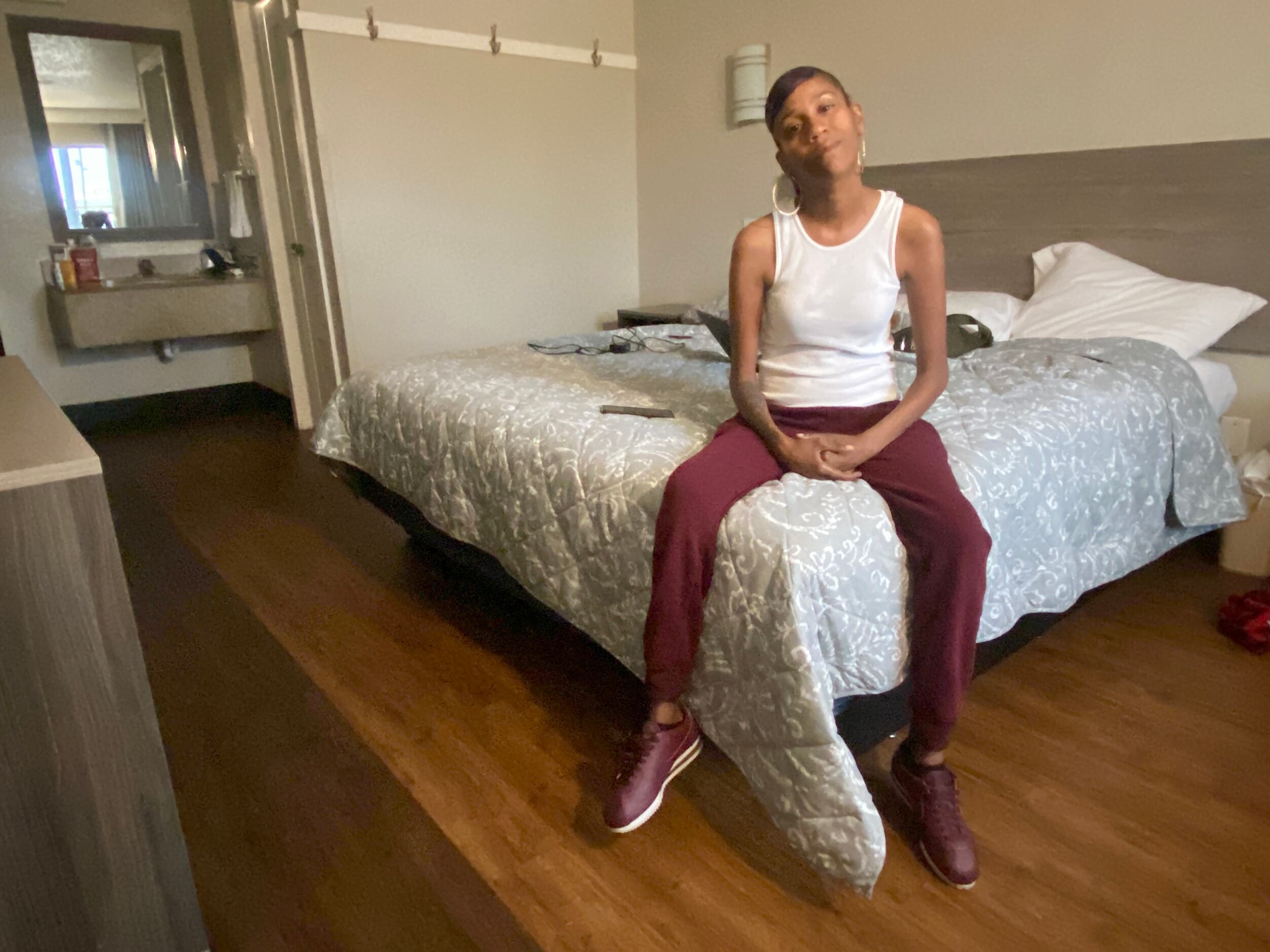 Brittany Jones, 41, sits on her bed at the Budget Inn of Texas in Mesquite. Like other...