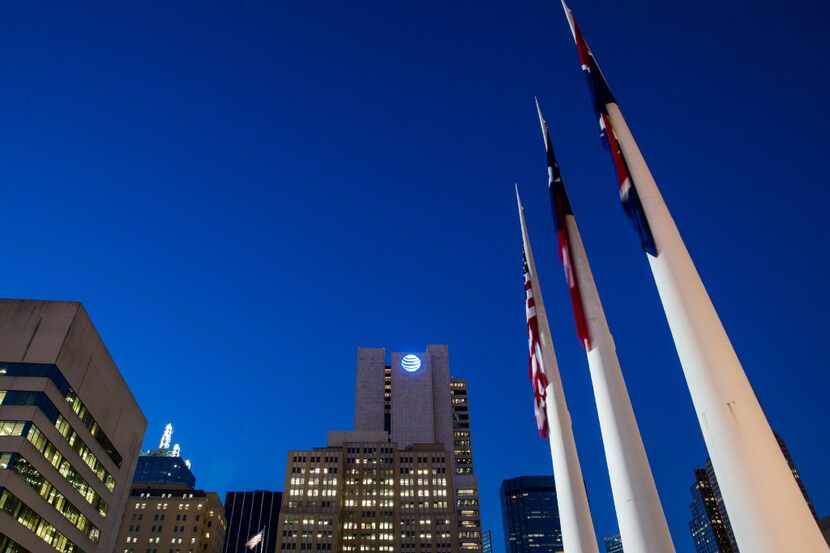The AT&T headquarters building, center, surrounded by other downtown buildings and flags in...