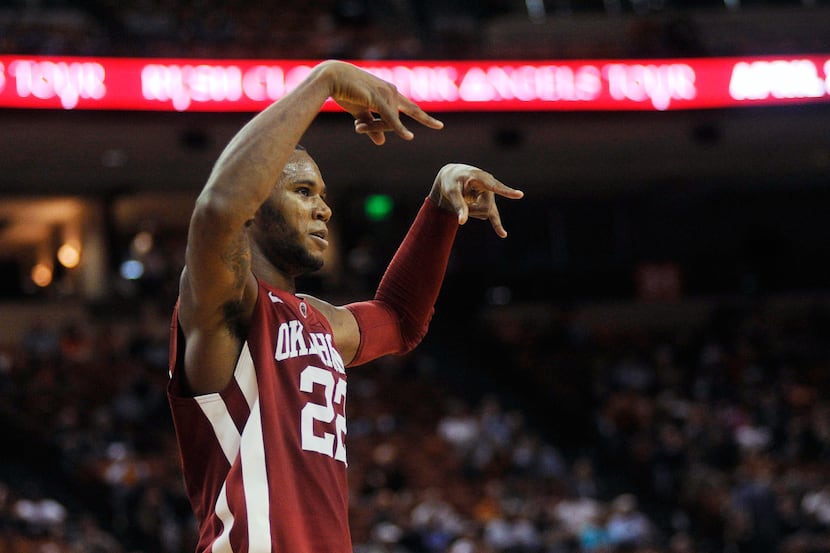 Oklahoma's Amath M'Baye signals "horns down" to the Texas crowd after a dunk in the second...