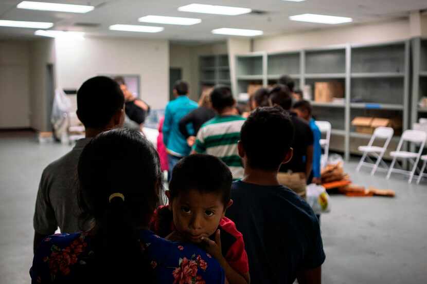 Varias familias formadas en la línea para recibir comida en la Casa del Refugiado, un centro...