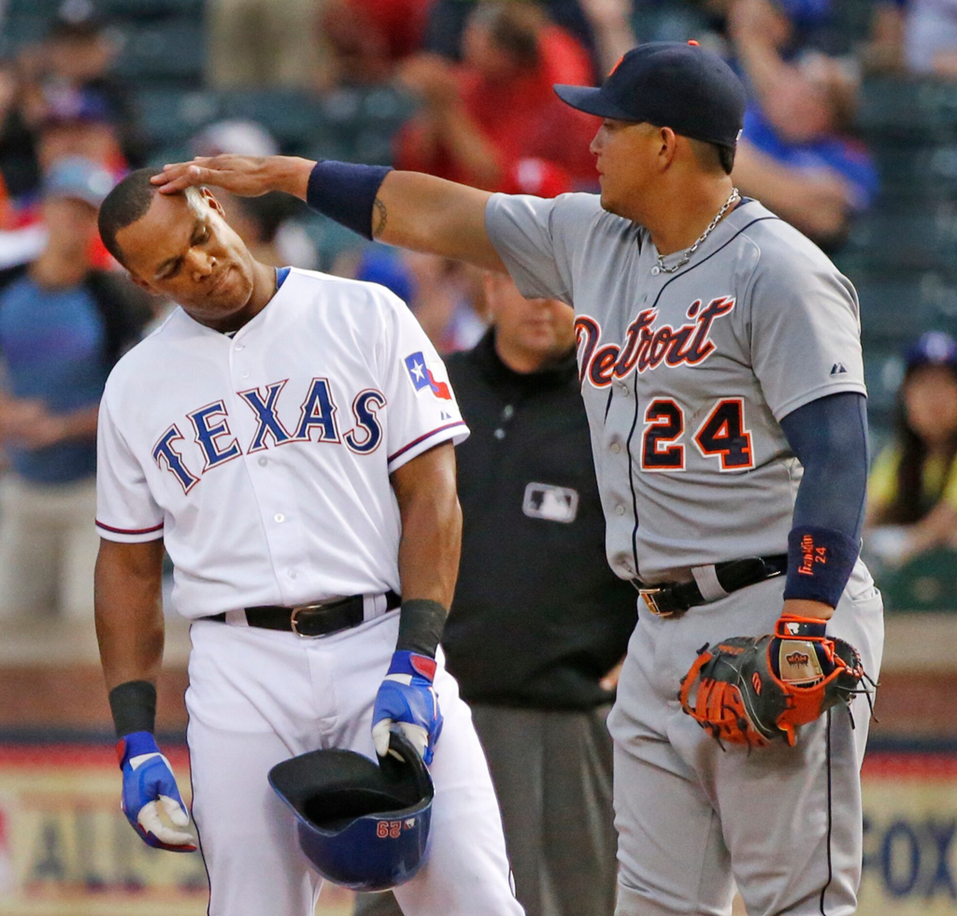 Detroit first baseman Miguel Cabrera playfully  touches the head of Texas third baseman...