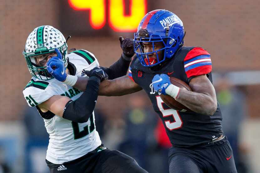Duncanville running back Malachi Medlock (5) delivers a stiff-arm to Southlake Carroll...
