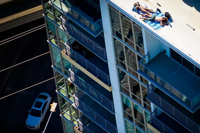 Aerial view of a couple sunbathing on the roof of the The Katy in Victory Park Apartments on...