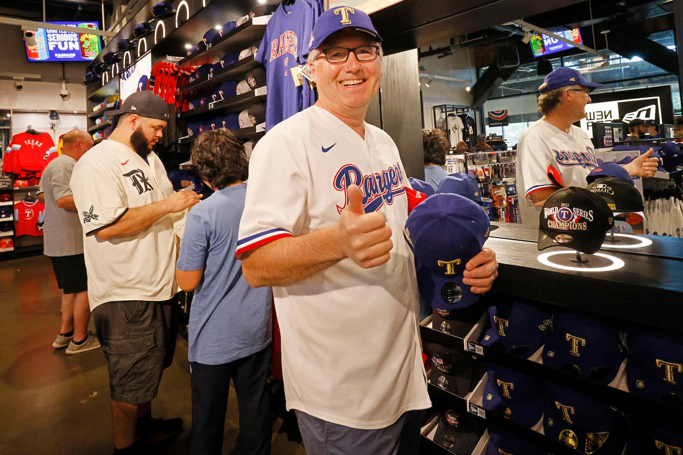 Texas Rangers fan Jeff Scott of Rockwall, Texas, gives a thumbs-up as he tries on a Rangers...