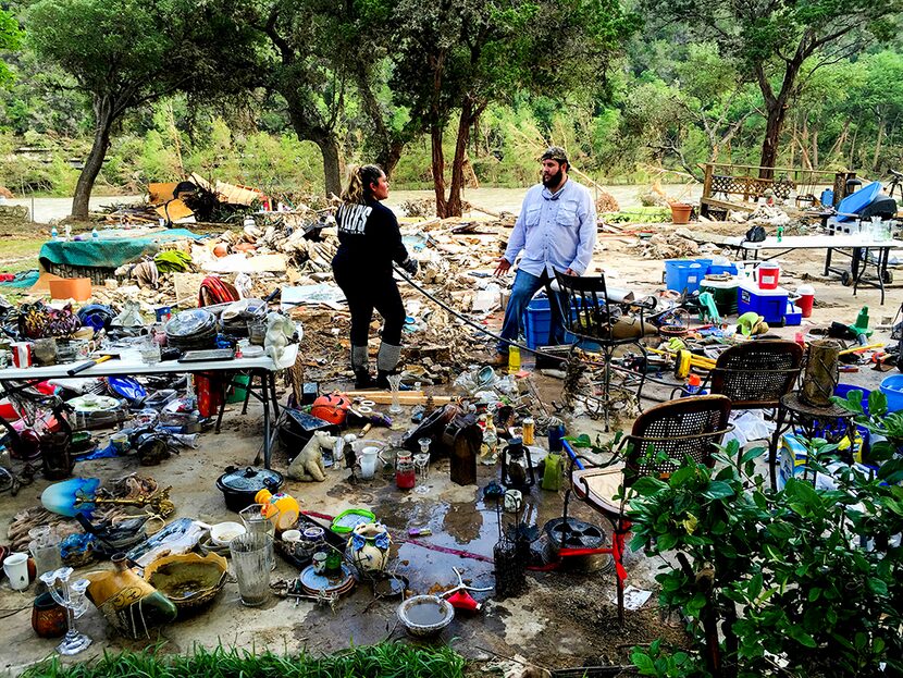  Volunteers sort through salvaged personal items in the former site of a bed and breakfast...