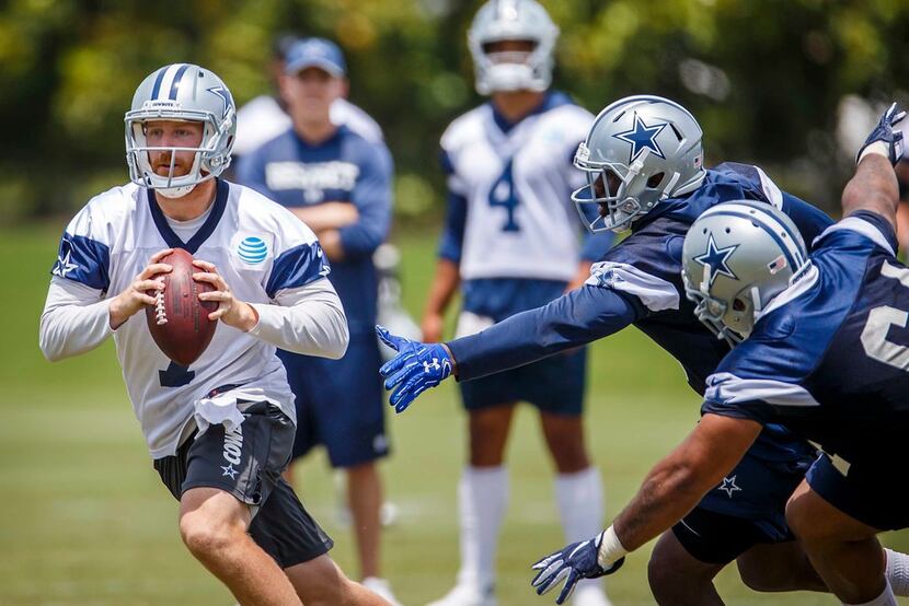Cowboys quarterback Cooper Rush (7) avoids the pass rush during minicamp at The Star on...