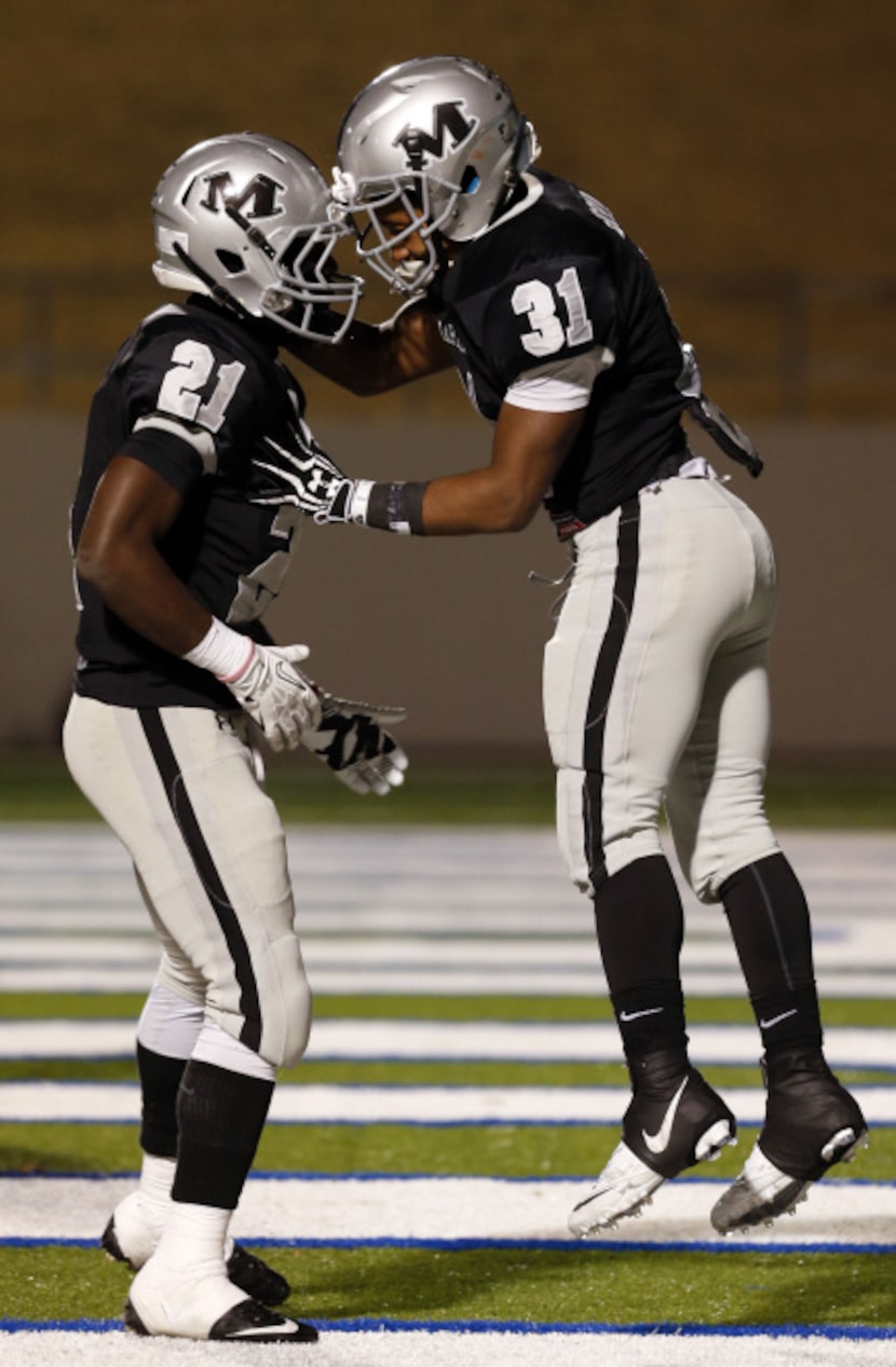 Arlington Martin High's Nic Smith (21) and Jalum Bouldin (31) celebrate Bouldin's running...