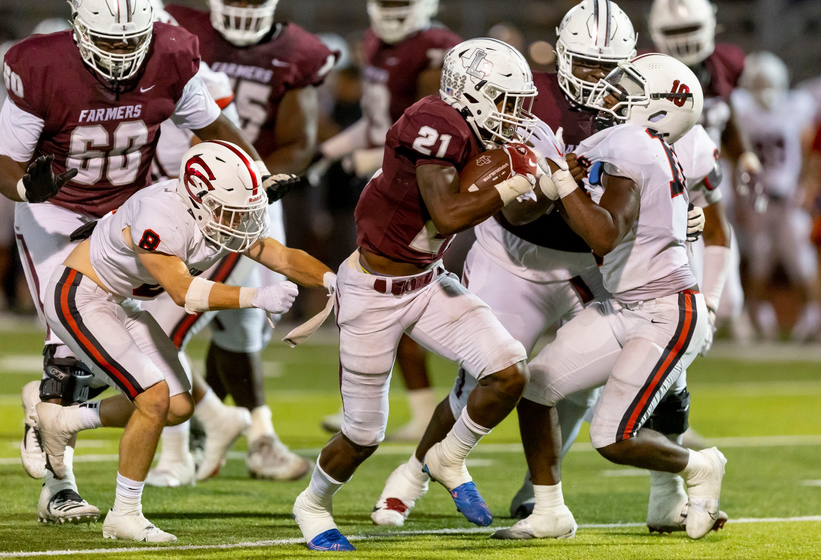 Lewisville junior running back Viron Ellison (21) battles the Coppell defense during the...