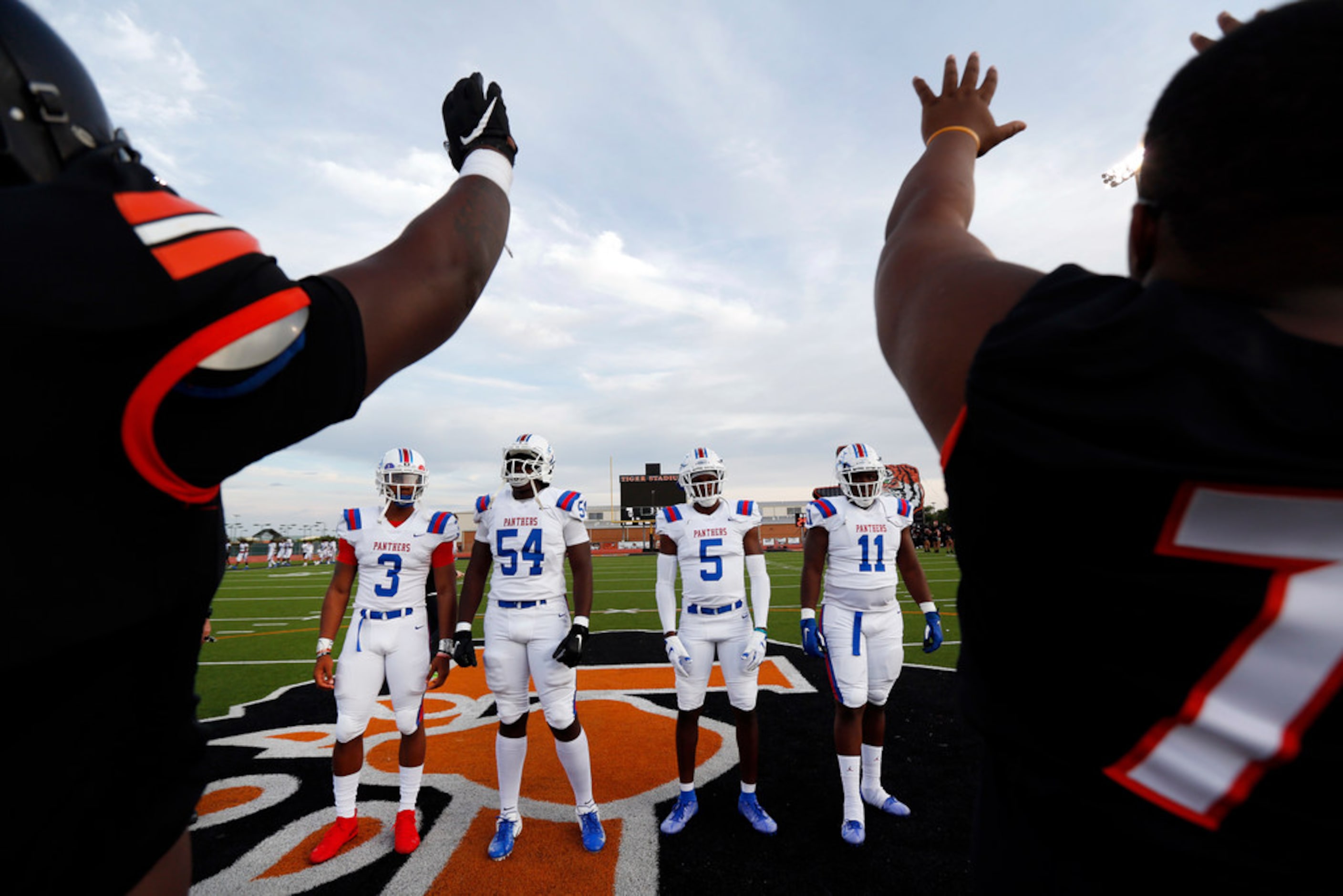 Lancaster team captains raise the hands as their team is introduced.  Duncanville team...