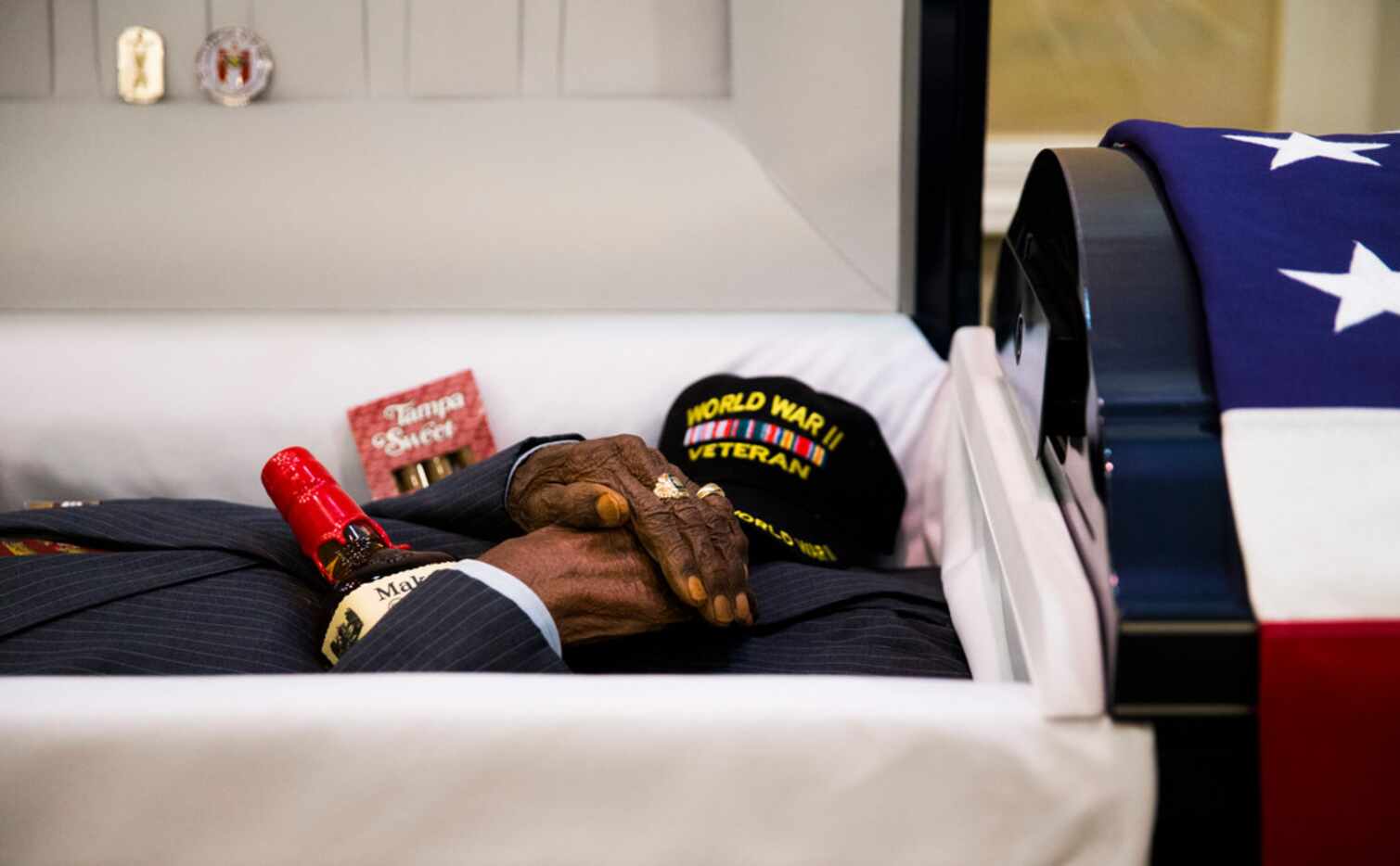 Richard Overton's hands rest on a bottle of Maker's Mark Whiskey and Tampa Sweet cigars lay...