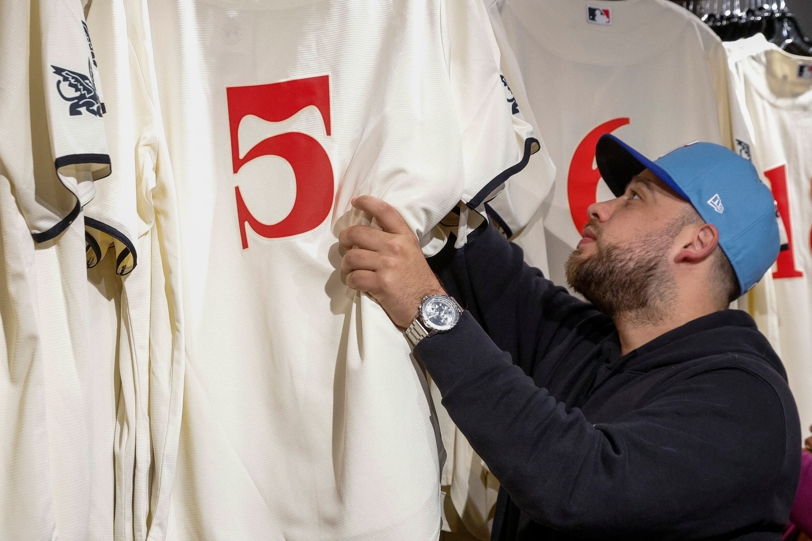 Andrew Vega searches for his size in the new Texas Rangers City Connect Jersey at Globe Life...