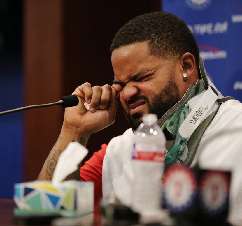 Texas Rangers designated hitter Prince Fielder wipes away a tear while speaking in a press...