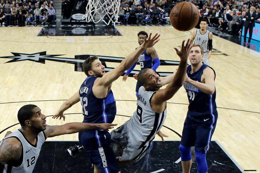 San Antonio Spurs guard Tony Parker (9) drives to the basket between Dallas Mavericks...