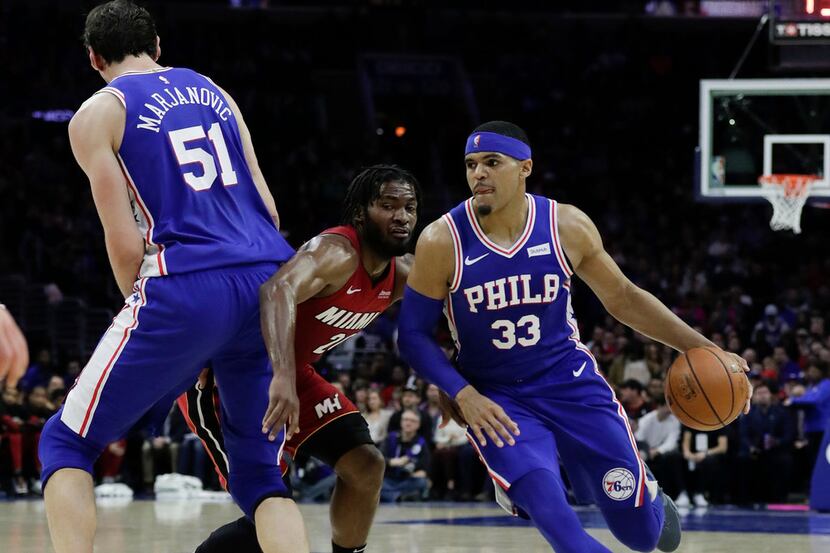 The Philadelphia 76ers' Tobias Harris (33) drives off a screen from teammate Boban...